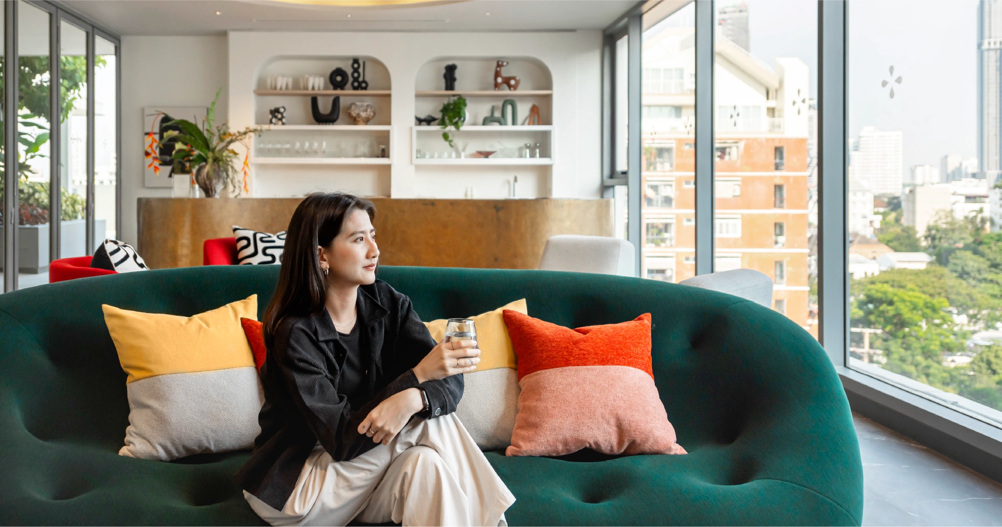 ผู้หญิงนั่งพักผ่อนในพื้นที่ส่วนกลางของคอนโดใหม่จากสโคป