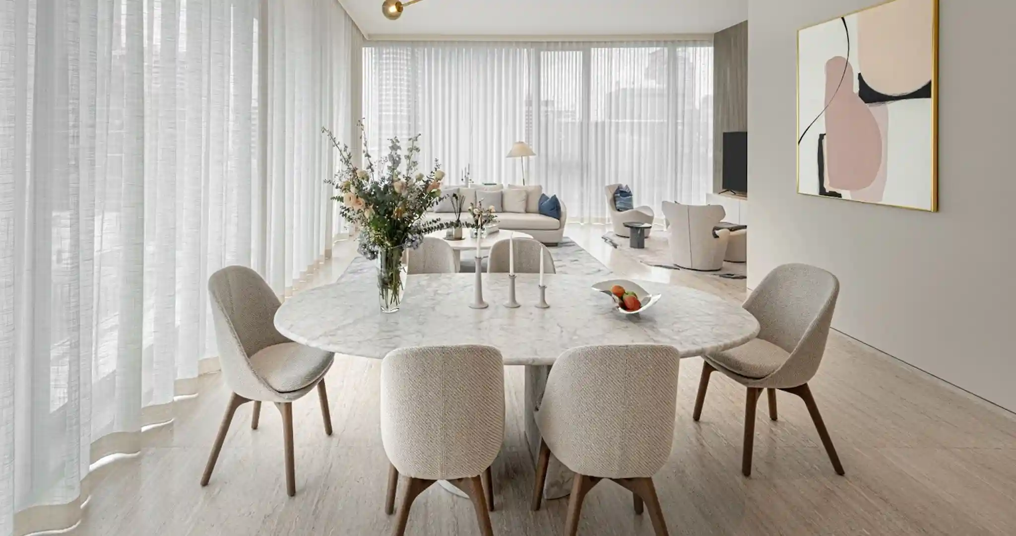 Inside the living room of an ultra luxury condo, decorated with beige furniture.