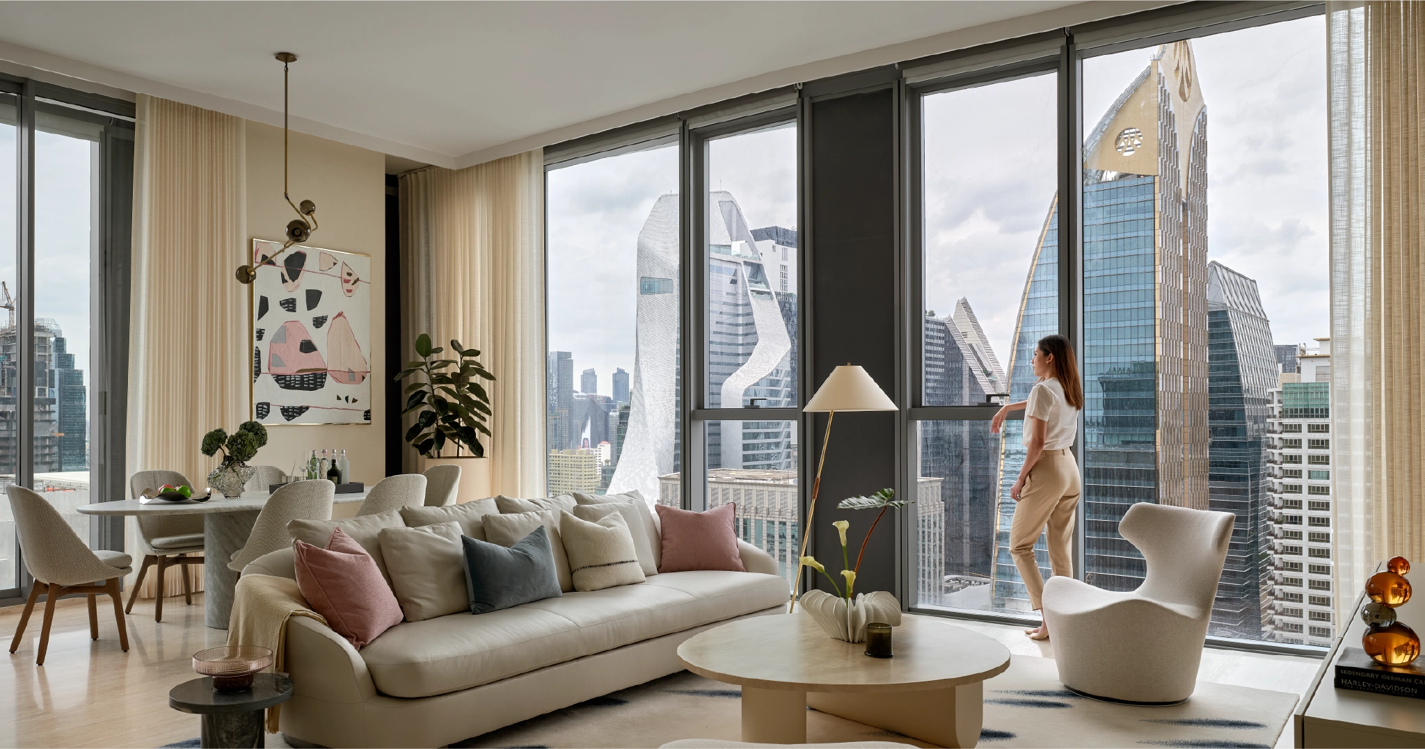 ผู้หญิงยืนอยู่บริเวณหน้าต่างเพื่อมองวิวจากคอนโดมิเนียมหรู