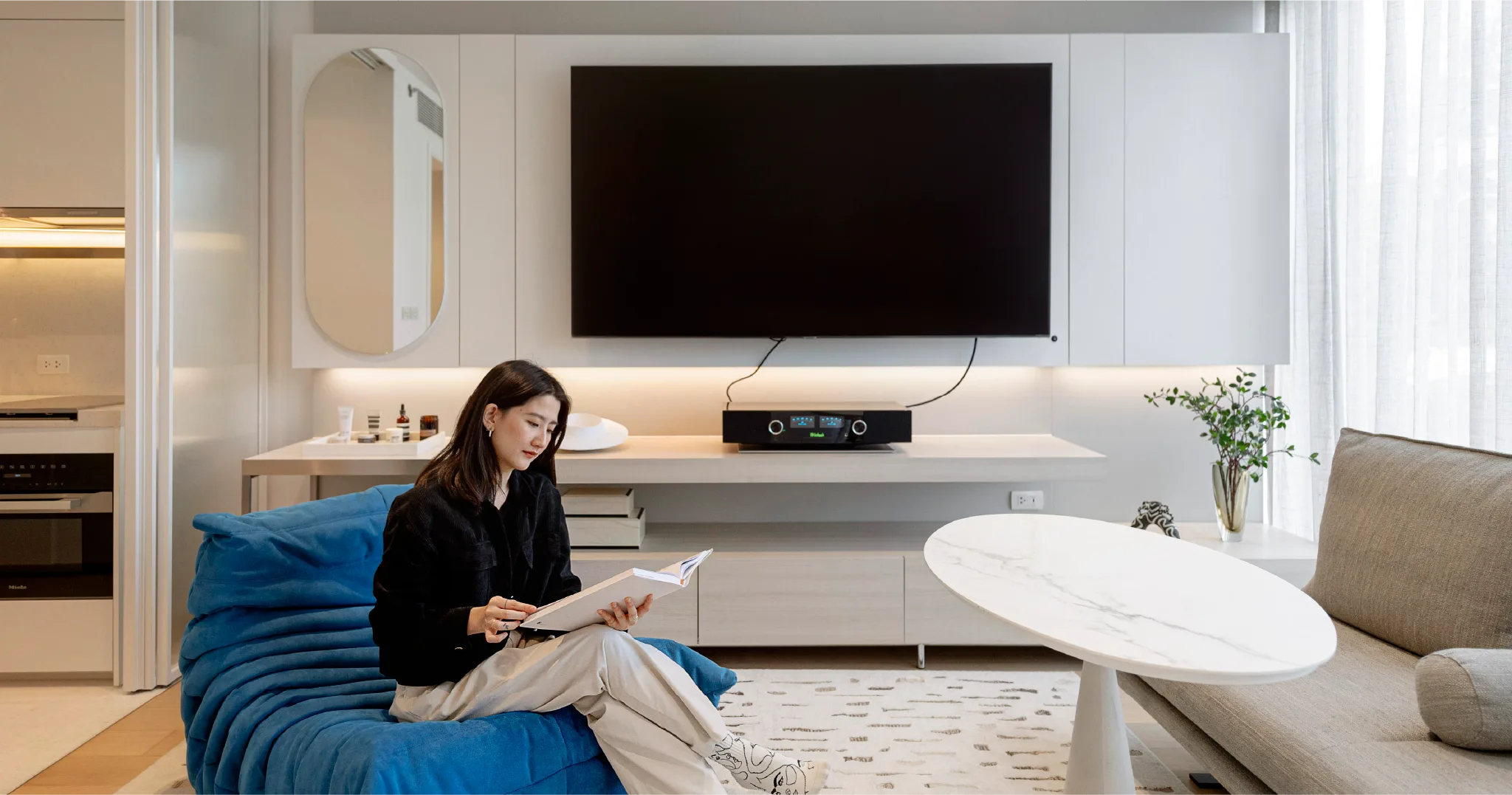 คนนั่งเล่นในห้องพักของสโคปพร้อมศรี เหมาะสำหรับลงทุนคอนโดปล่อยเช่า